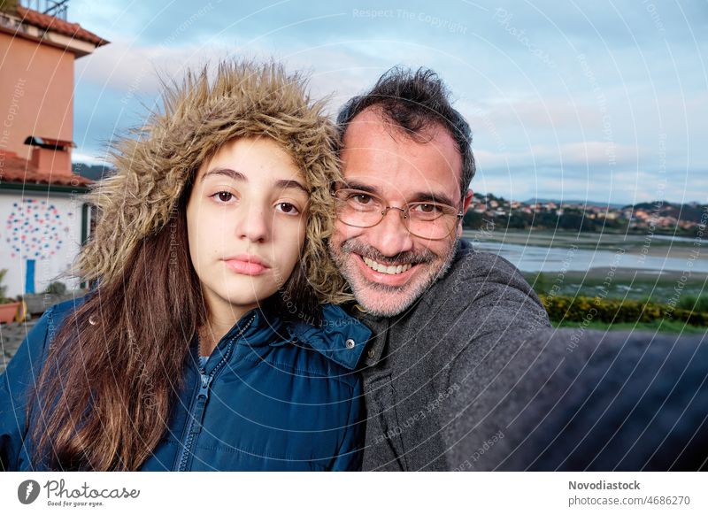 Portrait of two people, father and daughter, isolated outdoors, on a winter's day couple family outside portrait teenager girl caucasian happy young parent man