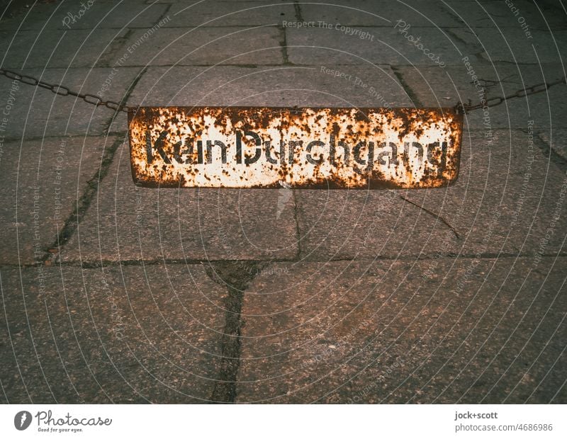 No passage really hangs there for a long time no passage Signs and labeling Metal Barrier Rust Weathered German Characters Paving tiles Iron chain Berlin
