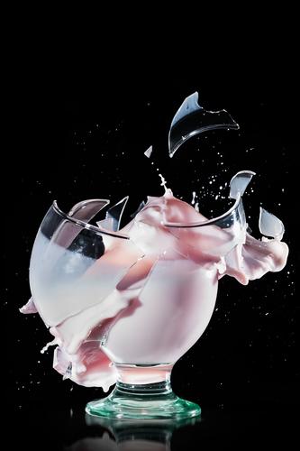 Glass cup breaks and spills its contents. High speed photography on black background To break (something) Nonsense Milk Splash Drinking White Eyeglasses Liquid