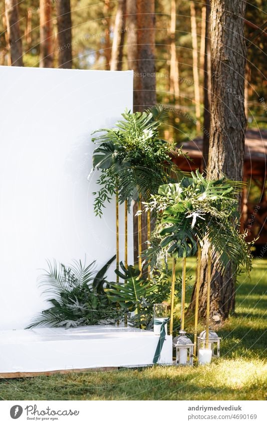 Wedding decorations in luxury ceremony. Arch for wedding ceremony a is decorated with flowers and greens, greenery. wedding decor outdoors in the forest on summer sunny day.