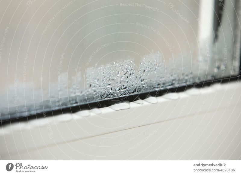 a plastic window with condensation of water on the glass. Double glazed PVC window. Concept: defective plastic window with condensation, temperature difference, cooling, humidity in the room.