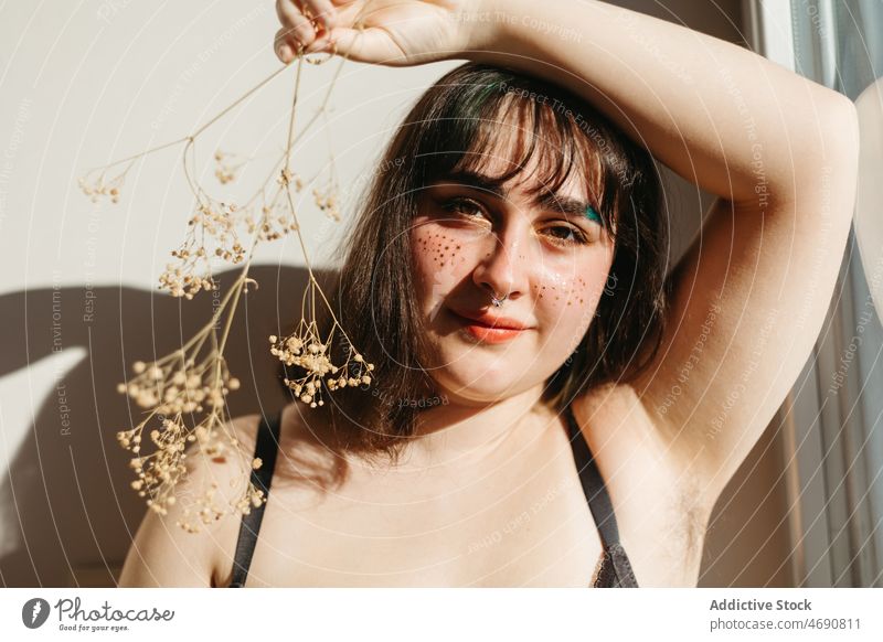 Overweight woman in underwear with dried flowers plus size twig figure sunlight smile lingerie room enjoy feminine windows delight home content female body
