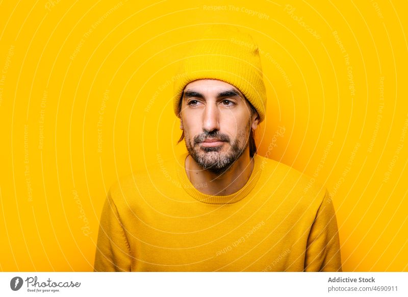 Man with eyes closed in yellow studio man appearance mood beard portrait male unshaven color colorful light friendly carefree guy vivid style unemotional