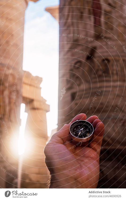 Unrecognizable traveler with compass in Hypostyle hall hypostyle tourism column ancient medieval historic trip orientate culture antique history old egypt