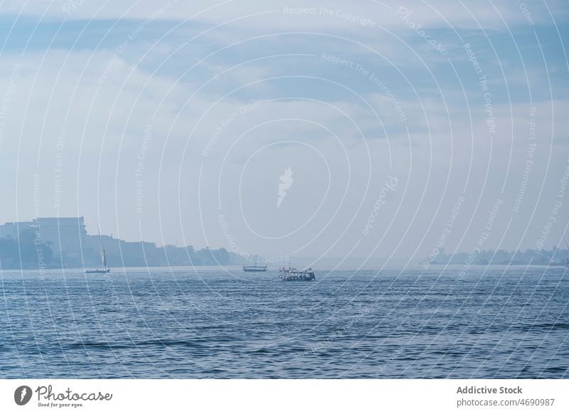 Boats floating on rippling sea water boat vessel shore transport coast waterside seascape summer building cloudy ripple egypt environment surface aqua nautical