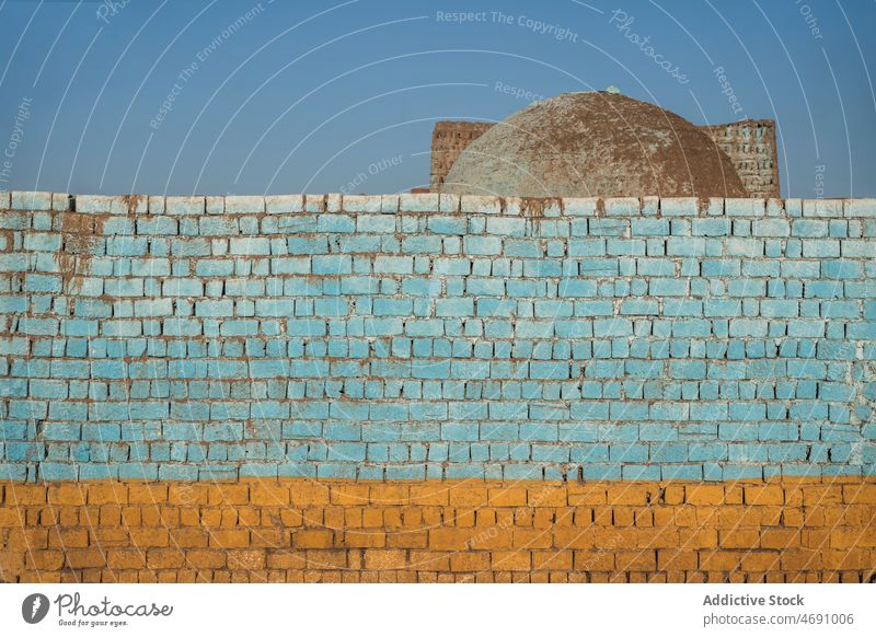 Old painted brick wall on street shabby weathered old building local style colorful town egypt worn out district structure city aged part light dome blue sky