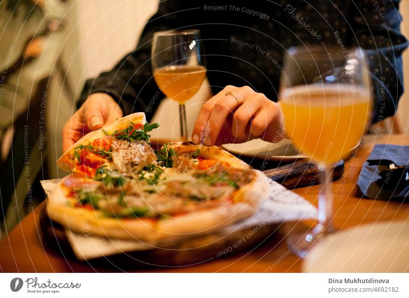 Pizza and glasses of craft beer closeup on table. Eating pizza and drinking beer with a friend at pizzeria or on a date in restaurant. Food and drink. Delicious meal.