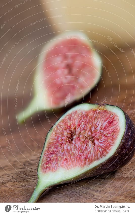 A halved fig in front of hard cheese Fig Fruit Mature Fruit flesh Sámen Side dish shallow depth of field Dish Food