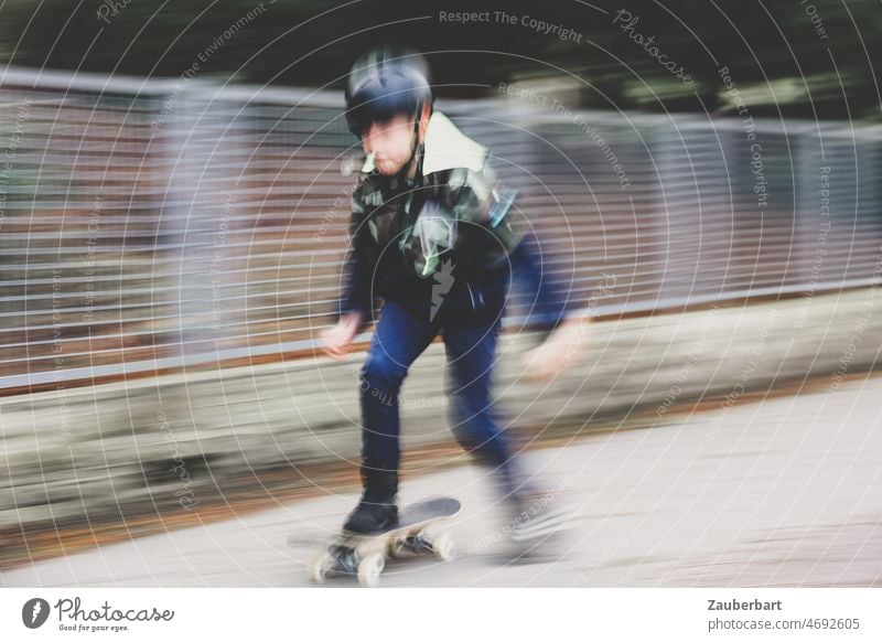 Boy rides skateboard on sidewalk as pull-along wipes out Boy (child) Skateboard steep Drag-along blurred Movement blurriness Skateboarding Joy Athletic