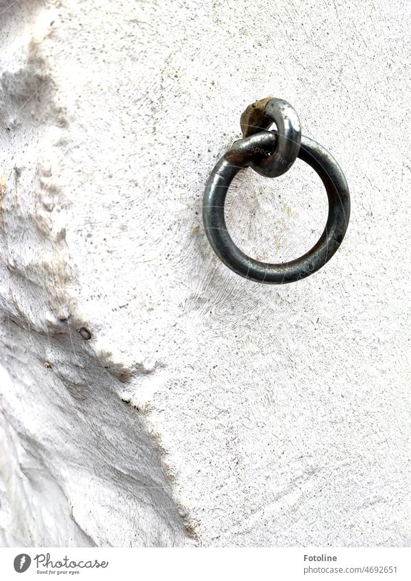 A metal ring attached to a whitewashed wall, from which a piece has already broken out. Ring Metal Iron Steel Wall (barrier) Wall (building) White Gray Detail