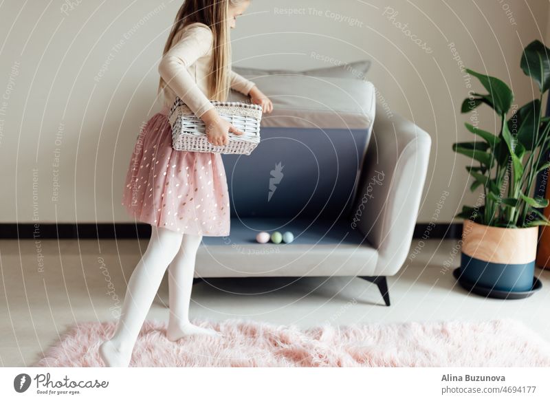 happy caucasian toddler girl eight years old at home in living room with colored easter eggs. Stay home during Coronavirus covid-19 pandemic holiday child kid