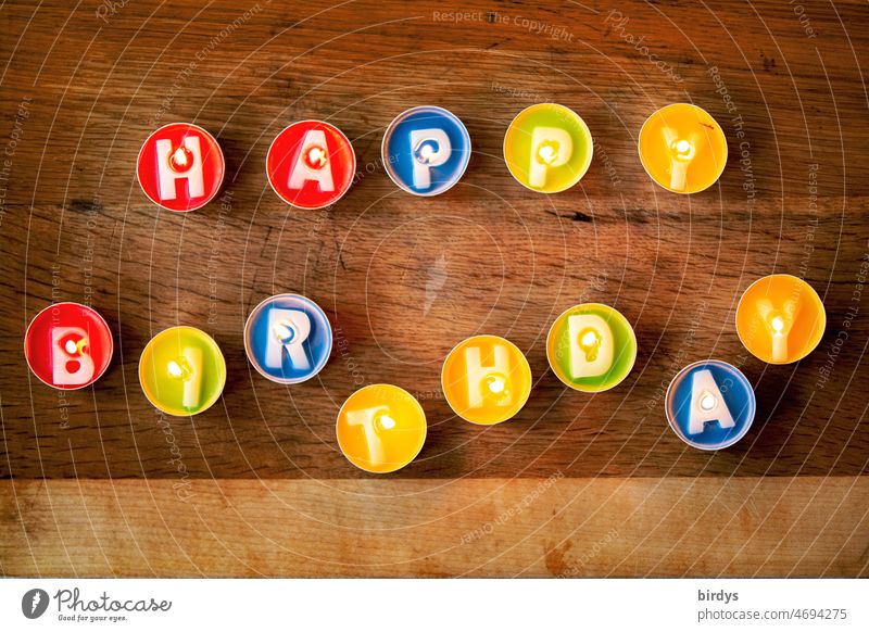 Happy birthday. Colorful , burning tea lights with letters as a birthday greeting . Birthday Tea lights Letters (alphabet) Happy Birthday variegated
