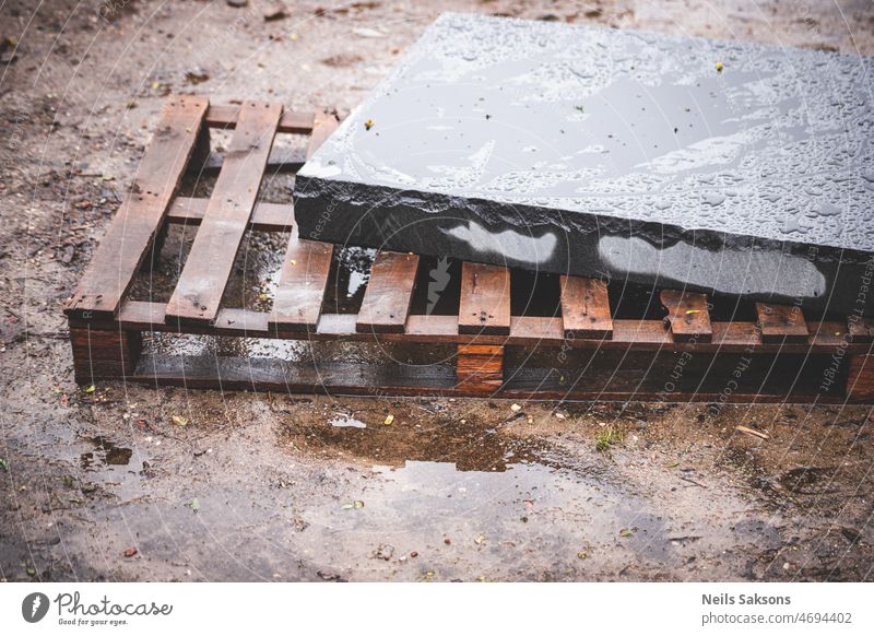 slab of black granite on wooden palette in rainy day architecture background backsplash block cement concept concrete construction factory floor gray grey