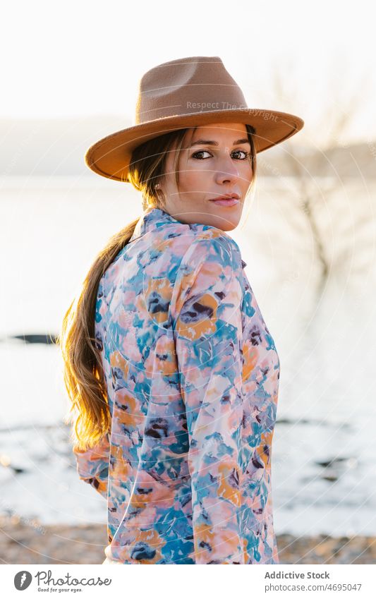 Enigmatic woman in hat on beach style water river nature enigmatic feminine summer countryside coast shore sensitive female headwear headdress overexposed