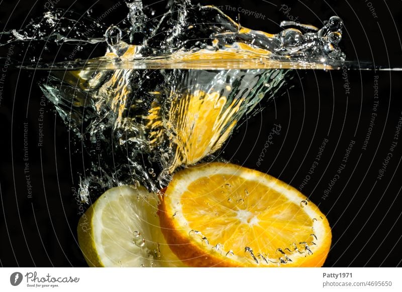 Underwater shot of orange & lemon slice falling into water. Orange Lemon splash Underwater photo Water Splash of water Fresh Close-up fruit Inject Wet