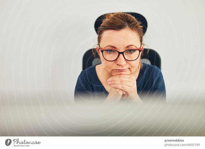 Woman entrepreneur focused on solving difficult work. Confused businesswoman thinking hard looking at computer screen frustration problem deadline