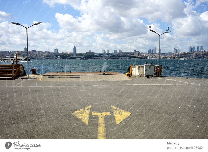 Yellow arrows at the pier of the ferry across the Bosphorus in the summer sunshine in Üsküdar in Istanbul, Turkey Summer Town Season City outlook panorama