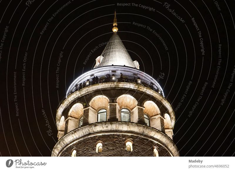Round arches of the Galata Tower illuminated from inside at night in summer in the Galata district in the old city of Beyoglu in Istanbul on the Bosporus in Turkey