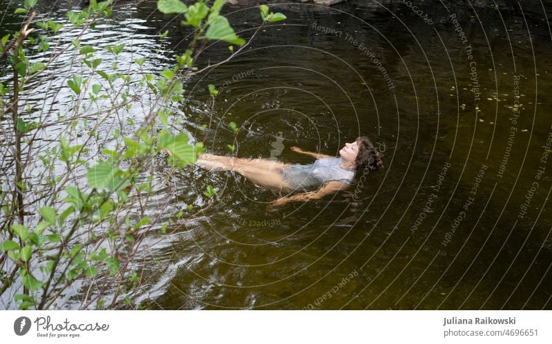 Woman swimming relaxed in lake Life Smiling Esthetic Environmental protection closeness to nature leaves Joie de vivre (Vitality) Contentment Closed eyes