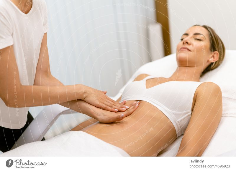 Middle-aged woman having a belly massage in a beauty salon. abdomen people female spa body relax massaging masseur wellbeing treatment care therapy wellness