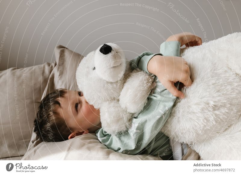 Cute girl with toy on bed kid childhood bedroom morning domestic bed time pajama bear cozy embrace apartment smile adorable flat cute hug home residential