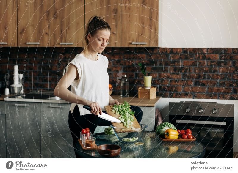 Sports woman cooking healthy eat at home salad celery pepper lifestyle kitchen vegan diet vegetables preparation concept beautiful food ingredients happy