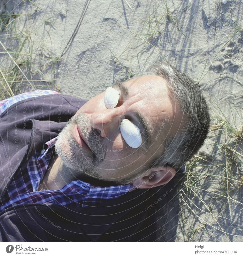 Enjoying spring sun - portrait of senior citizen lying on the sand in the sun Human being Man Senior citizen Head sun protection Mussel Spring Beach sunshine