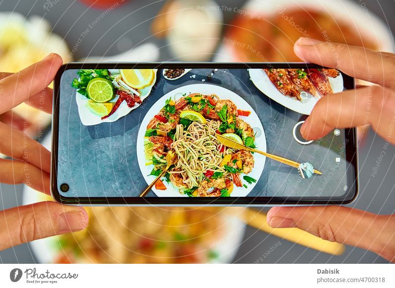 Taking photo of stir fry noodle with smartphone for social media food photography wok soba asian nutrition cuisine mobile pov restaurant recipe share kitchen