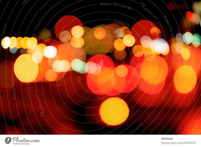 Blurred red and orange bokeh background. Blur abstract background of urban light. Warm light with beautiful pattern of round bokeh. Light in the night. Street lamp lights in the city at dark night.