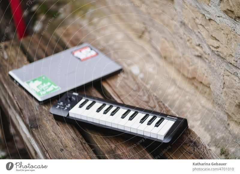 Mini keyboard and laptop on wooden bench Composer Musical instrument midiboard tool keyboard instrument Piano Keyboard Make music Musician