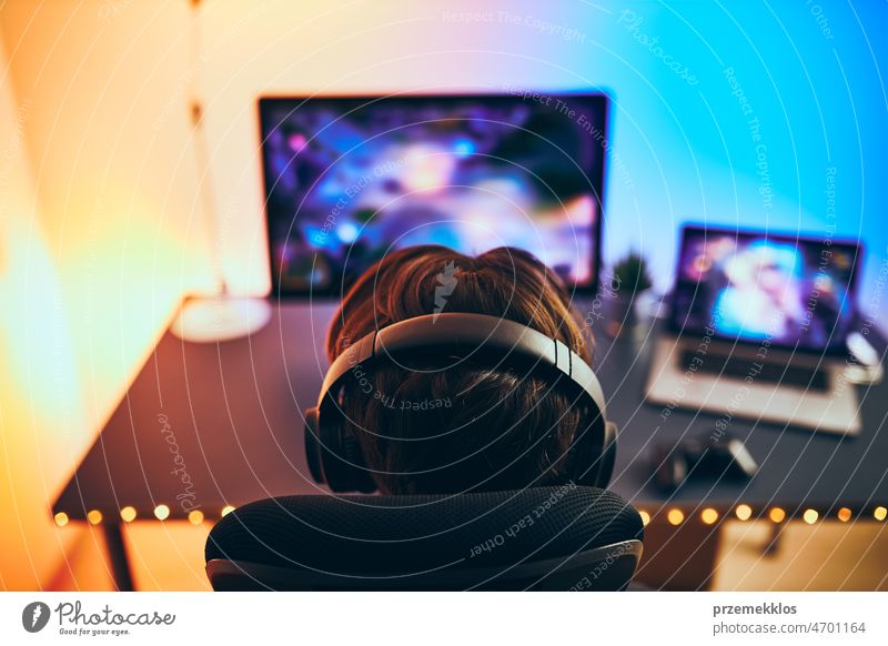 Man playing video game at home. Gamer playing online in dark room lit by neon lights. Competition and having fun gaming competition gamer technology cyber