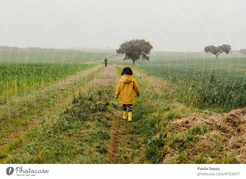 Rear view girl with Yellow jacket Child Girl 3 - 8 years Nature holiday Autumn Authentic Field Playing Multicoloured Leisure and hobbies Happiness Exterior shot