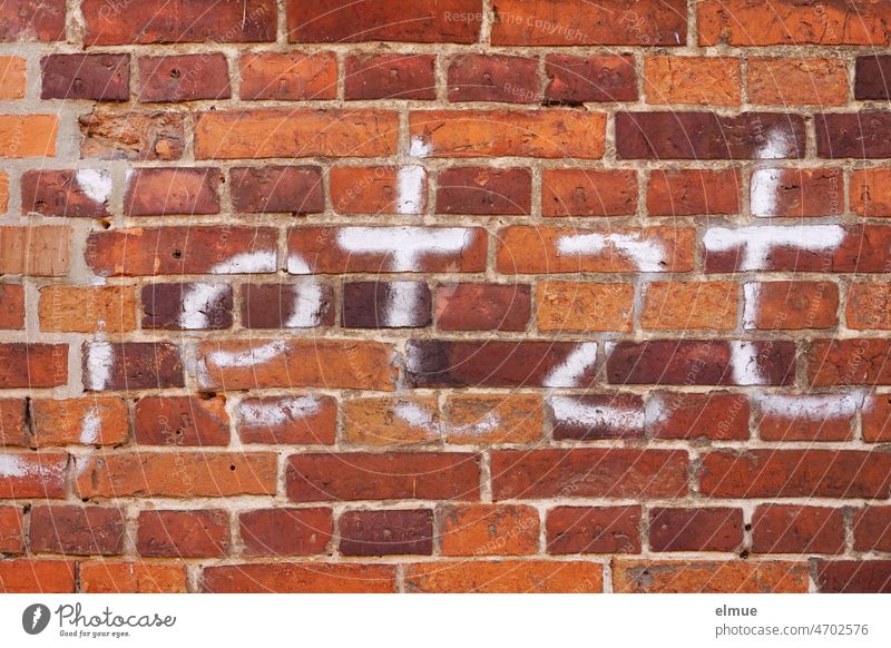 now - is written in white letters on the red brick wall / graffiti / time Graffiti now or never Red Point in time Wall tile at the drop of a hat Time