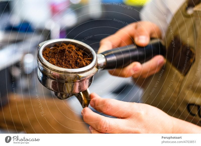 Closeup of female barista hand holding ground coffee for preparing espresso. tamper portafilter grinder hands business design retro food person office art