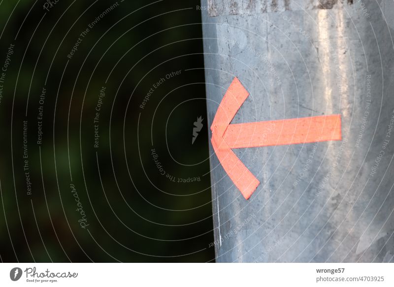 An arrow stuck on a lamppost points to the left Lamp post Marking arrow arrow icon direction arrow Adhesive tape Arrow Direction Signs and labeling Orientation