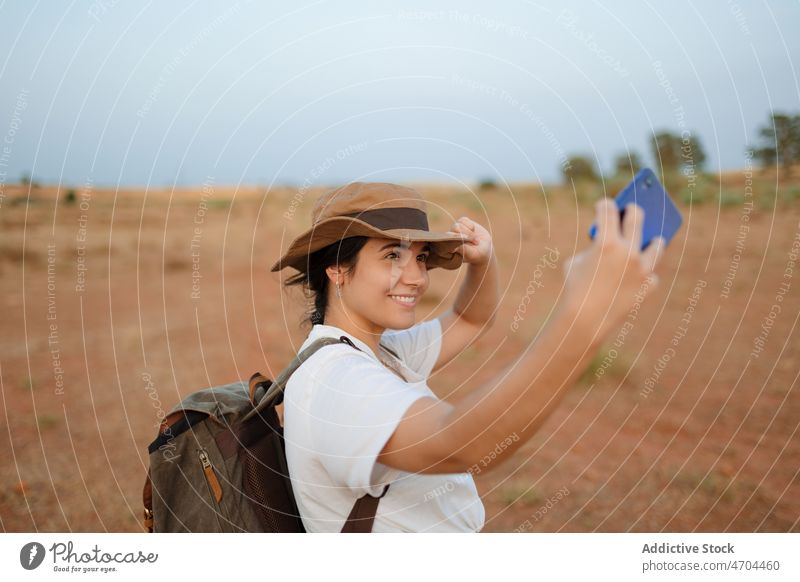 Woman taking selfie in desert woman traveler smartphone social media capture arid discovery journey explore smile self portrait memory happy photography hobby
