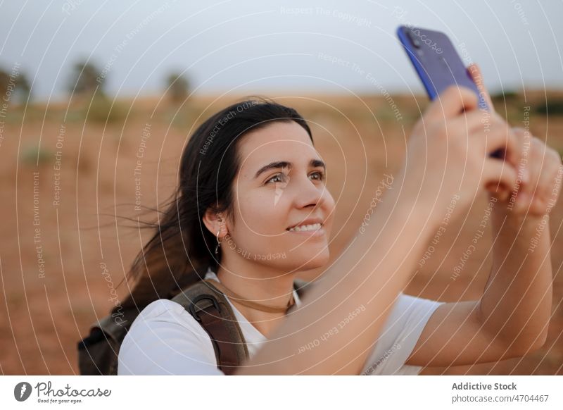 Woman taking selfie in desert woman traveler smartphone social media capture arid discovery journey explore smile self portrait memory happy photography hobby