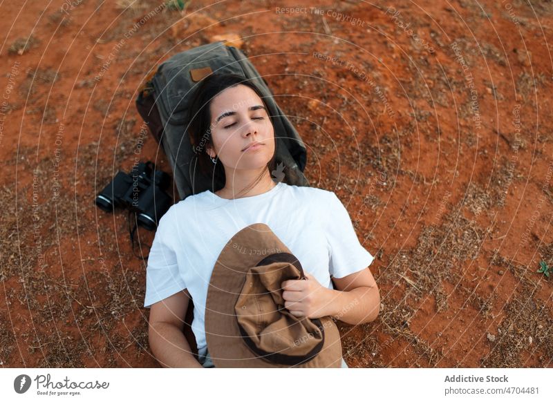 Woman lying in desert area woman traveler trip adventure arid journey explore barren rest dry waterless eyes closed thoughtful tourism pensive tourist drought
