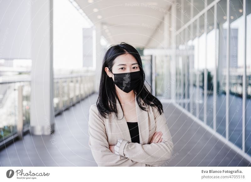 young business woman wearing face mask in city. corona virus concept chinese pandemic office co working glass reflection asian entrepreneur professional