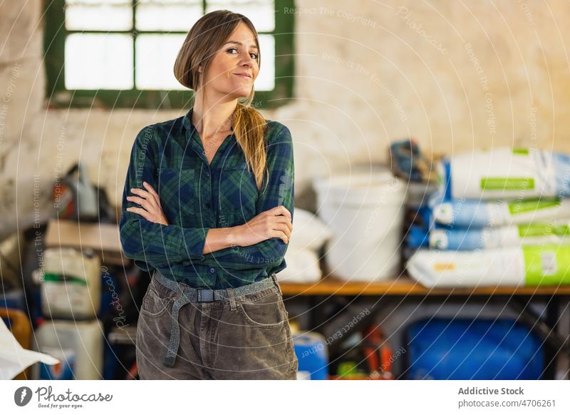 Smiling woman standing in barn farmer shed countryside agronomy industry industrial rural rustic worker light delight happy smile uniform female agriculture job