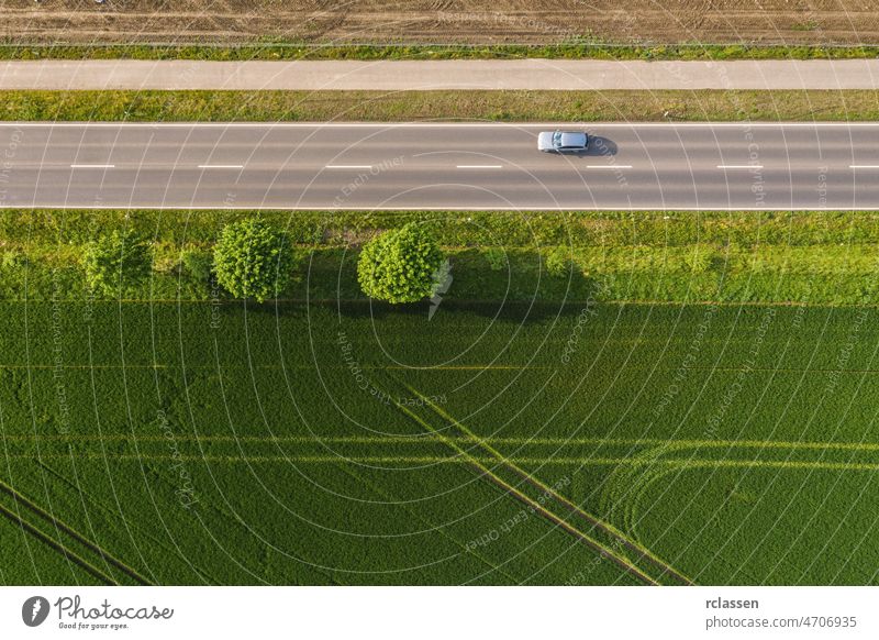 Aerial view of two lane road through countryside and cultivated fields with cars. Drone shot and copy space for text drone freeway trip aerial view agricultural