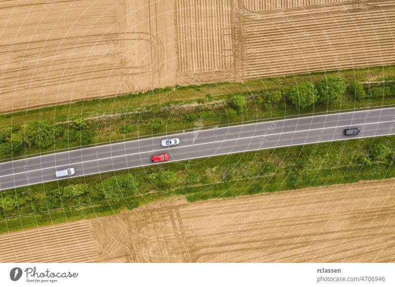 Aerial view of traffic on two lane road through countryside and cultivated fields drone freeway trip aerial view agricultural automobiles cars copy space