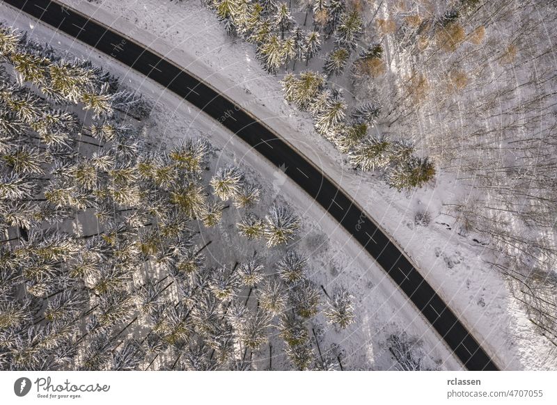 Aerial view of winter road in snowy forest. Drone captured shot from above drone aerial sunset sunlight flight day curve adventure background beautiful bird