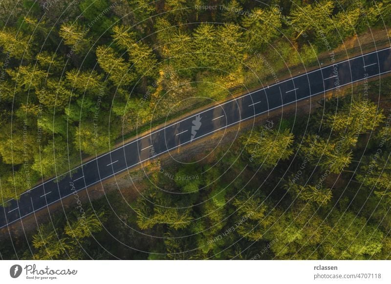 Aerial view of countryside road passing through the green forrest and mountain forest aerial drone eye landscape nature adventure asphalt grass natural outdoor