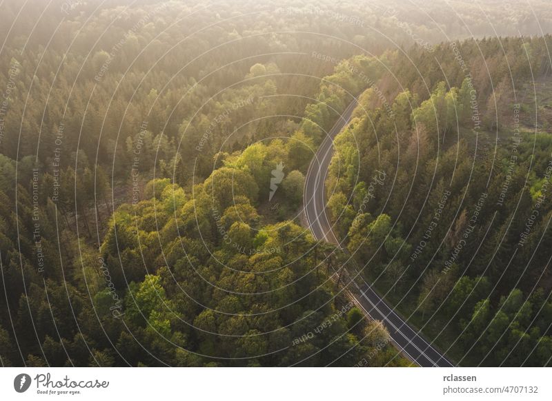 Aerial View of Road to the Mountains with mist, Top view of road through the trees shooting from drone forest aerial landscape fog highway eye car scenic clouds