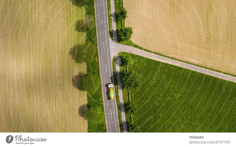 Aerial view of two lane road through countryside and cultivated fields with cars. Drone shot and copy space for text drone freeway trip aerial view agricultural