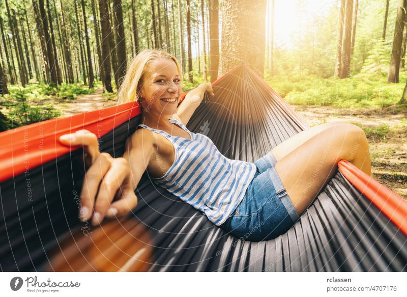 Cheerful woman enjoy in a hammock at the forest. outdoor travel concept image relax summer camping hiker comfort girl blond business tropical hiking lonely
