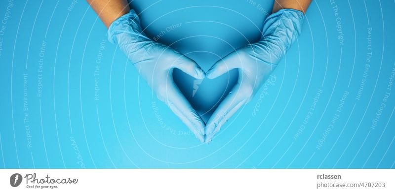 Doctor's hands in medical gloves in shape of heart on blue background, with copyspace for your individual text. covid 19 virus doctor corona nurse rubber