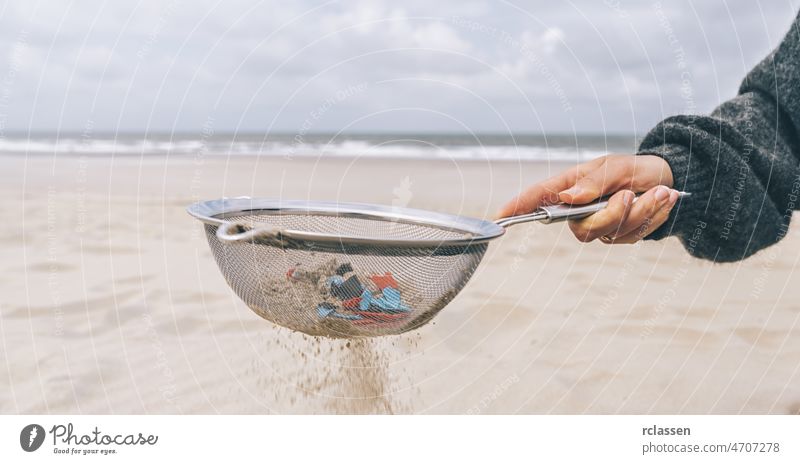 Young woman cleaning microplastics from sand on the beach, Environmental problem, pollution, ecolosystem and climate change warning concept hand marine europe