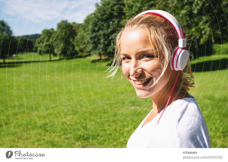 Female Runner Jogging during Outdoor Workout in a Park with headphones. copyspace for your individual text. happy park exercise runner spring summer workout jog
